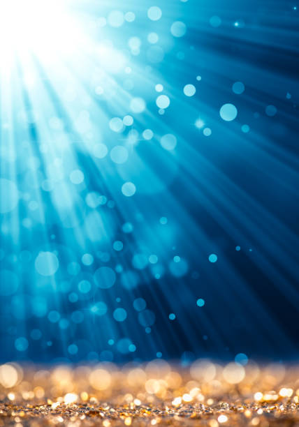 istock Blue light beam on gold defocused sparkles 872593828