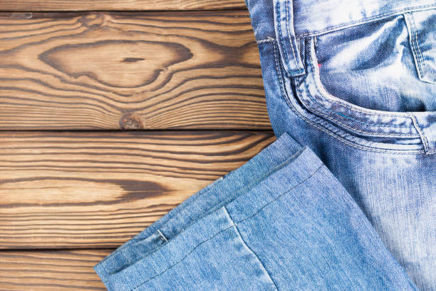 istock New blue jeans with empty pocket on old wooden rustic brown table 872594402