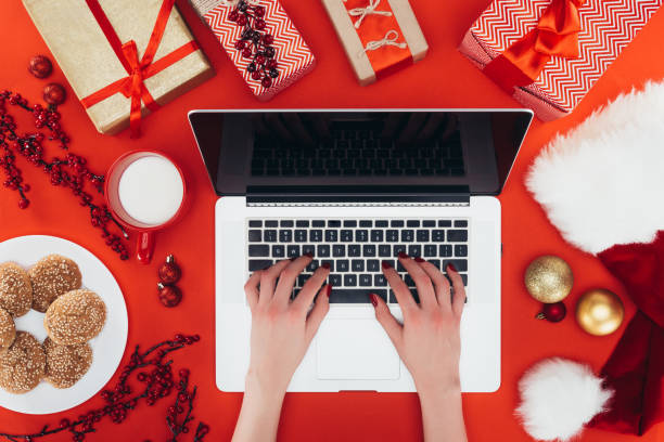 istock woman using laptop at christmastime 872597180