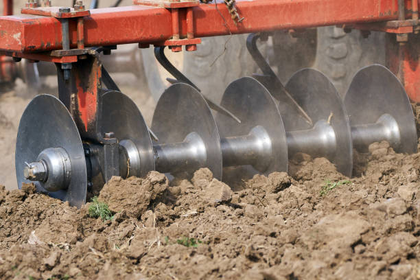 istock Tractor harrowing the field 872600402