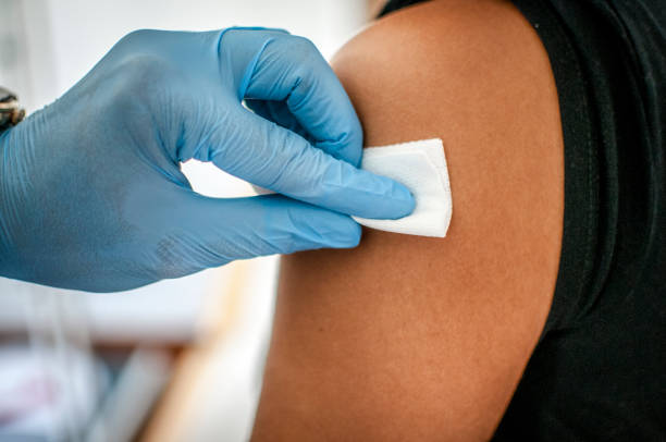 médico desinfecta a pele do paciente antes da vacinação - meningite - fotografias e filmes do acervo