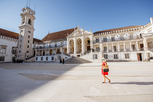 View on the courtyard of the old university building with woman walking in Coimbra city in the central Portugal