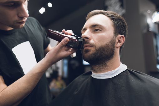 Barber Is Cutting A Beard To A Man In A Hair Salon Stock Photo - Download  Image Now - iStock