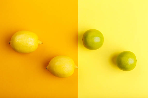 istock Lemon and lime on a yellow and orange background 872611792