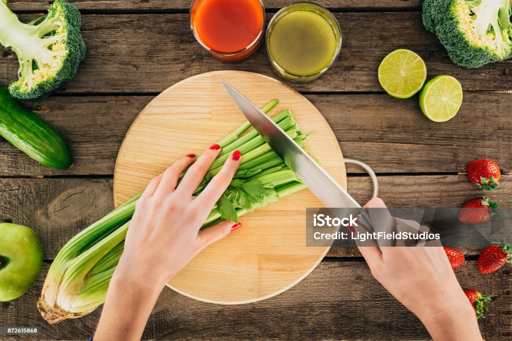 woman cutting celery cropped shot of woman cutting celery while cooking detox drink Celery Stock Photo