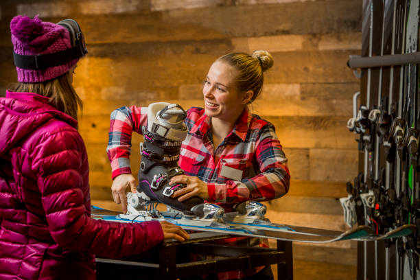 mujer asistente de ventas afinando esquís para el cliente. - snow gear fotografías e imágenes de stock