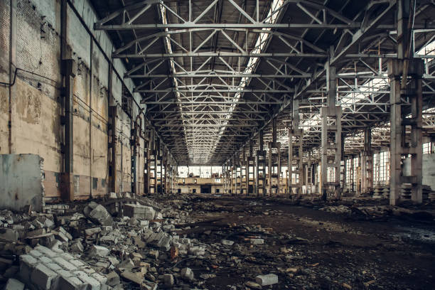 istock Large empty abandoned warehouse building or factory workshop 872625388