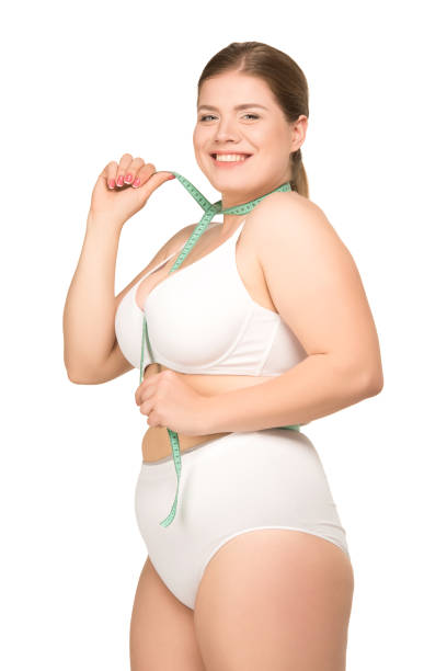 istock overweight woman measuring body 872628174