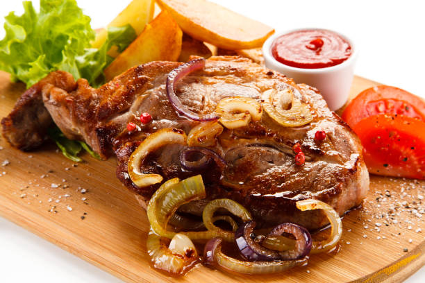 istock Grilled beefsteak, baked potatoes and vegetables on cutting board 872628640