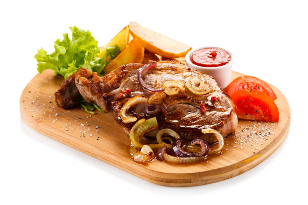 istock Grilled beefsteak, baked potatoes and vegetables on cutting board 872630802
