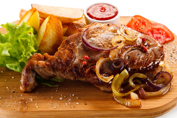 istock Grilled beefsteak, baked potatoes and vegetables on cutting board 872630862