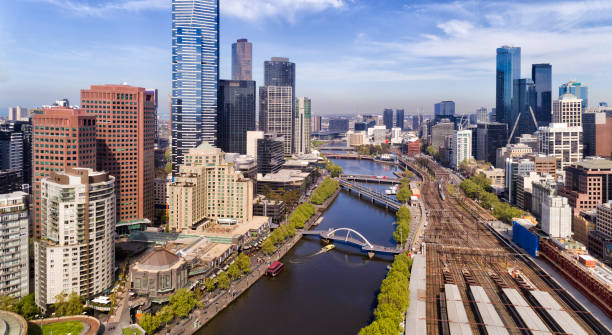 D Me CBD Close Elevated close-up view inside Melbourne city CBD over Yarra river waters and Flinders station railway platforms between suburbs of high-rise buildings. south yarra stock pictures, royalty-free photos & images