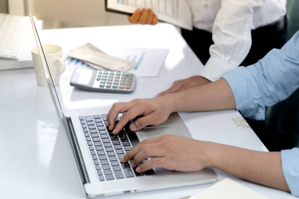 istock Top view desk of work table in office woth laptop computer , notebook , calculator and a cup of coffee for creative business work or marketing plan to success planning of company 872667044