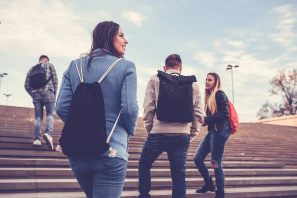 gruppe von studenten mit rucksäcken zu fuß zur schule - student adolescence college student teenager stock-fotos und bilder