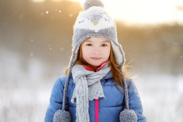 istock Funny little girl having fun in winter park 872673036