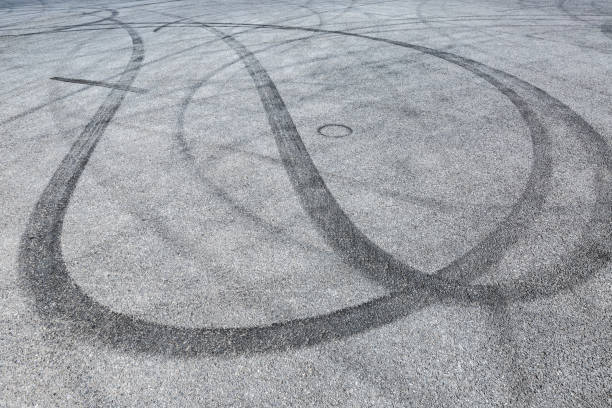 istock black tire tracks skid on asphalt road,abstract background 872673324