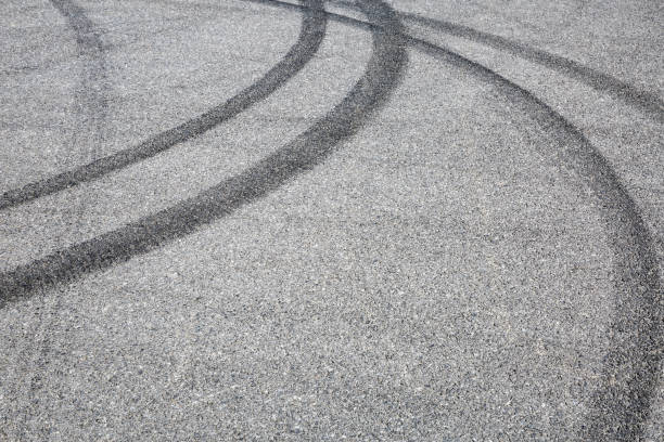 istock black tire tracks skid on asphalt road,abstract background 872673422