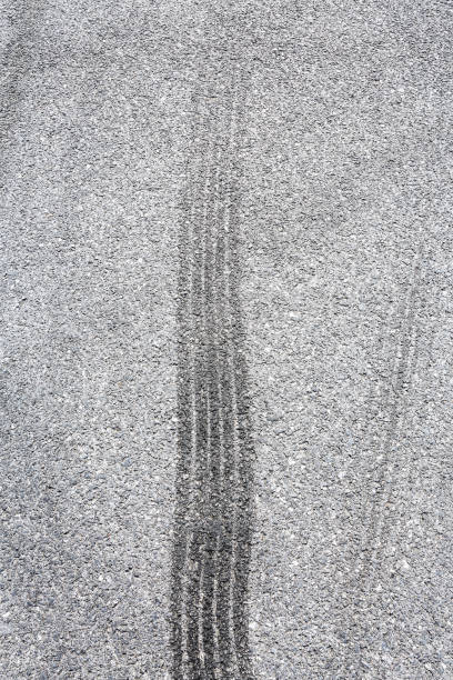 istock black tire tracks skid on asphalt road,abstract background 872676380