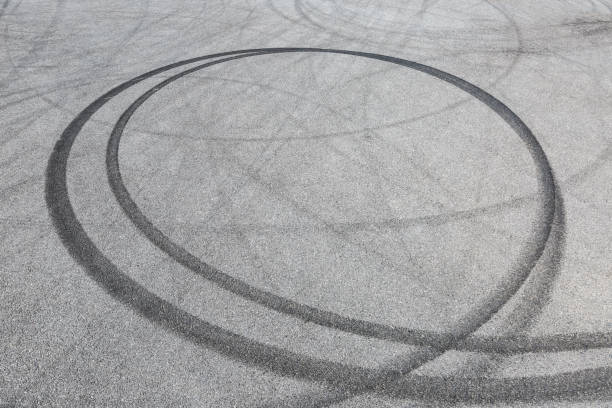 istock black tire tracks skid on asphalt road,abstract background 872676458