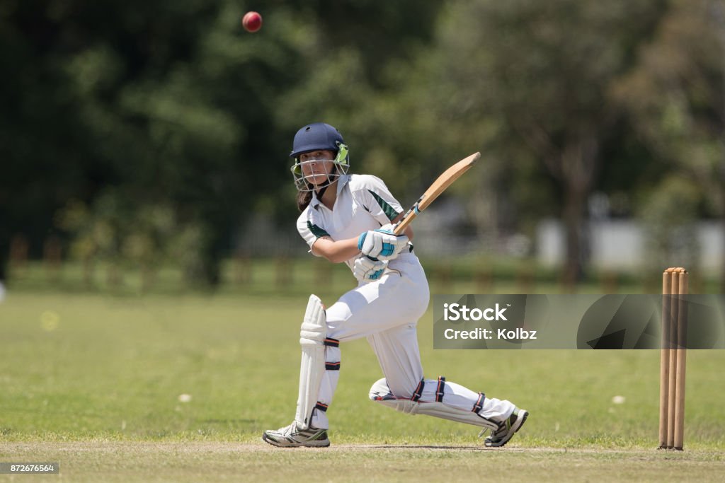 Girl playing cricket A girl batting as she plays in a cricket match Sport of Cricket Stock Photo