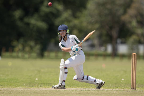 Girl playing cricket A girl batting as she plays in a cricket match cricket stock pictures, royalty-free photos & images