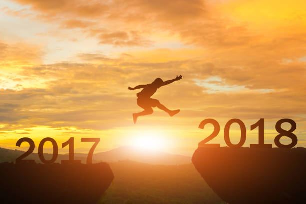 istock Men jump over silhouette Happy New Year 2018 872677362