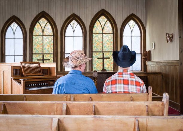 deux cow-boys caucasiens assis dans un banc d’église. - banc déglise photos et images de collection