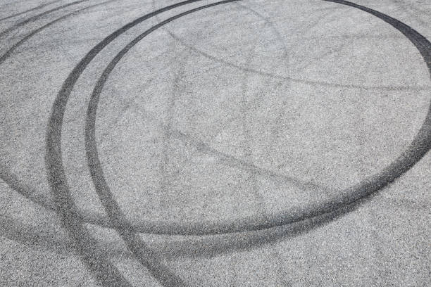 istock black tire tracks skid on asphalt road,abstract background 872679648