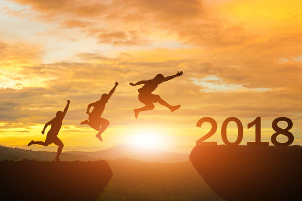 istock Men jump over silhouette Happy New Year 2018 872679962