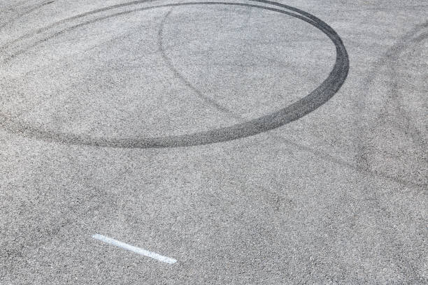 istock black tire tracks skid on asphalt road,abstract background 872679978