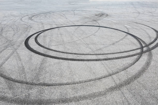 schwarze reifen spuren gleiter auf asphaltstraße, abstrakten hintergrund - tire track track asphalt skidding stock-fotos und bilder