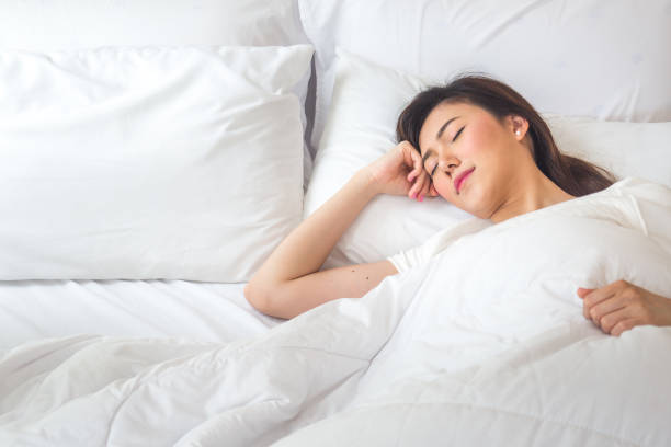 istock Beautiful asian woman sleeping on white bed with happy feeling 872680678
