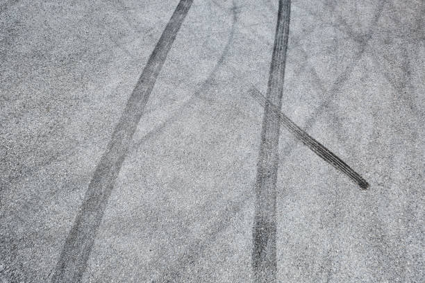 istock black tire tracks skid on asphalt road,abstract background 872680822