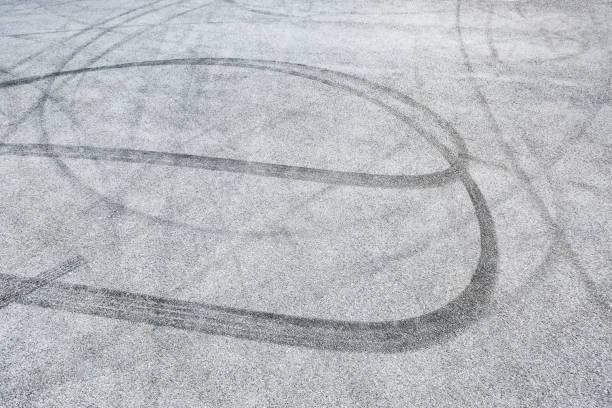 istock black tire tracks skid on asphalt road,abstract background 872683252