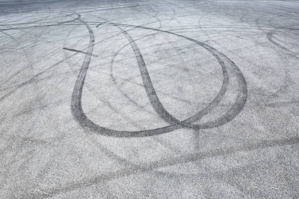 istock black tire tracks skid on asphalt road,abstract background 872683280