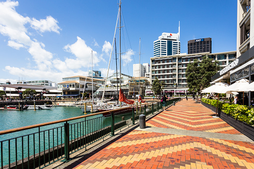 Auckland, New Zealand - February 22, 2017: A sailboat mooring in the Viaduct marina, lined by restaurants and trendy bars in Auckland's waterfront neighborhood in New Zealand.