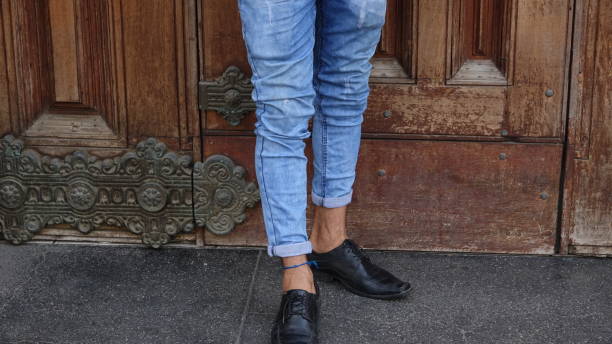 istock Male Legs And Feet And Blue Jeans 872683728