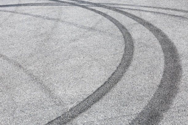 istock black tire tracks skid on asphalt road,abstract background 872687546