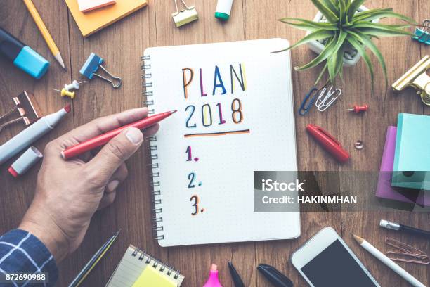 Plan 2018 Message With Male Hand Writing On Notepad Paper Stock Photo - Download Image Now