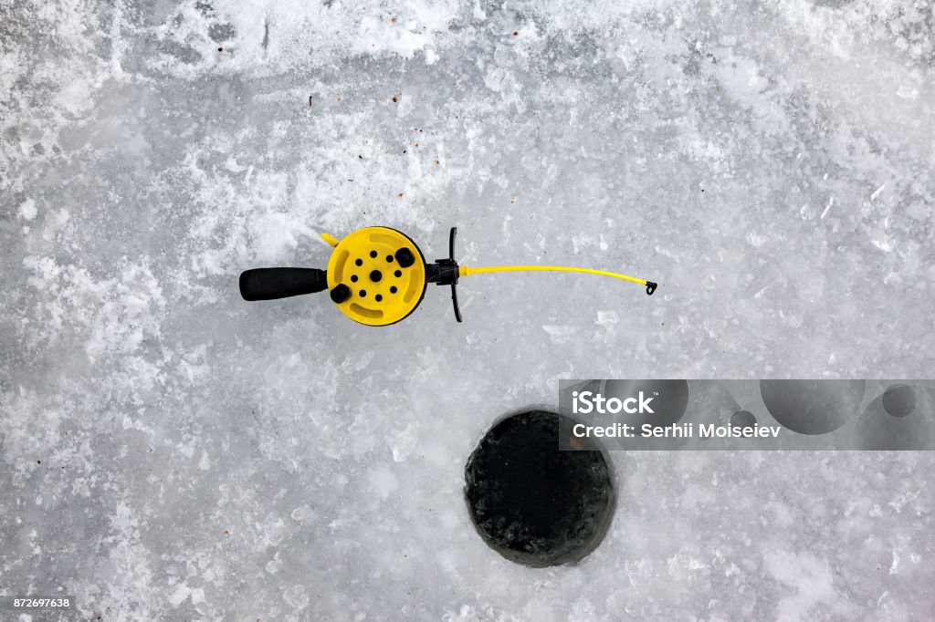 A winter fishing set An Ice-hole and a little plastic rod for winter fishing. Activity Stock Photo