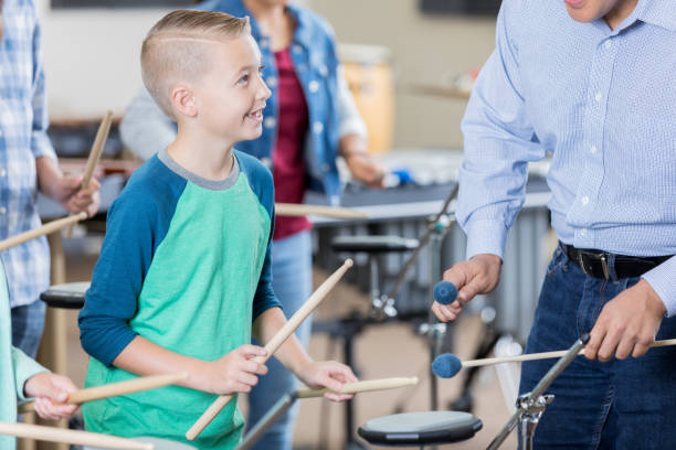 istock Elementary age boy listens attentively to band teacher 872698022