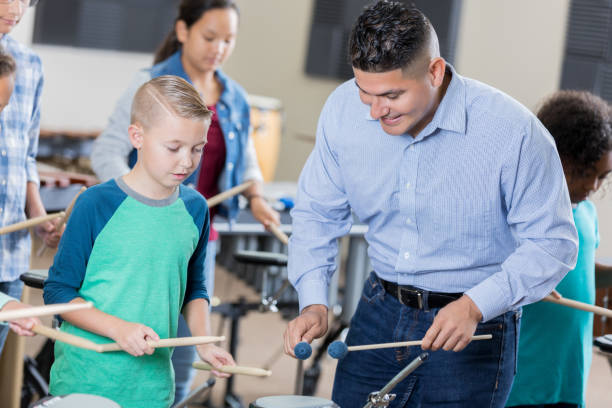 istock Band teacher demonstrates drumming techniques for music class 872698034