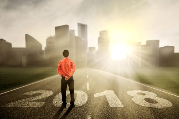 istock Young businessman with numbers 2018 on the paths 872703496