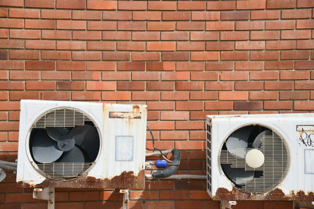 istock Old rusting metal exterior fitted air conditioning unit mounted on wall needing maintenance 872703554