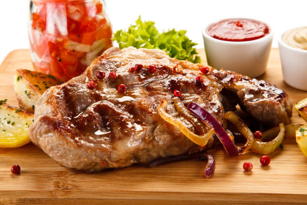 istock Grilled beefsteak, baked potatoes and vegetables on cutting board 872707772