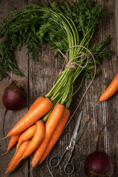istock Red carrot on wooden background table. Top view 872713788