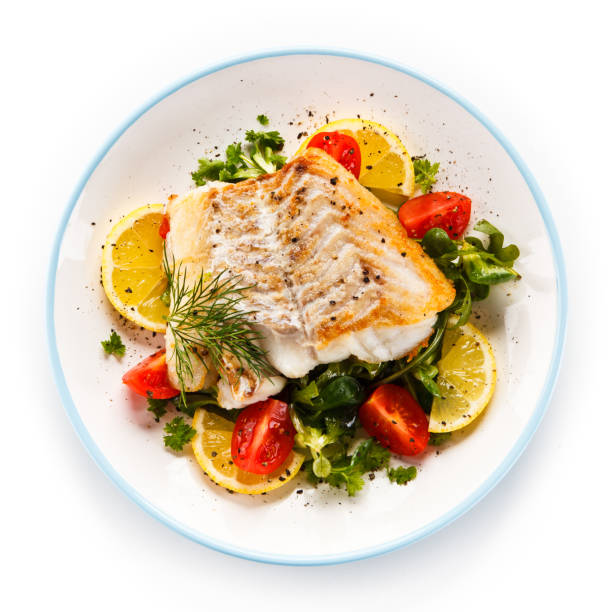 vis schotel - gebakken visfilet en groenten - kabeljauw stockfoto's en -beelden