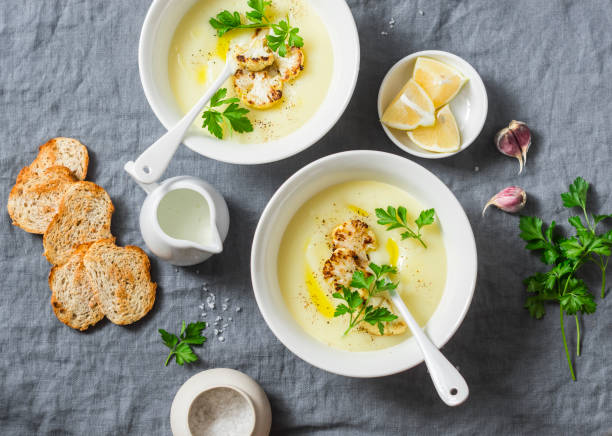 sopa de coliflor patatas puré sobre un fondo gris, vista superior. concepto de comida sana vegetariana - sopa de crema fotografías e imágenes de stock