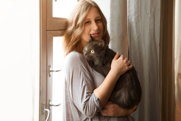 istock Young woman playing with cat in home. 872728648