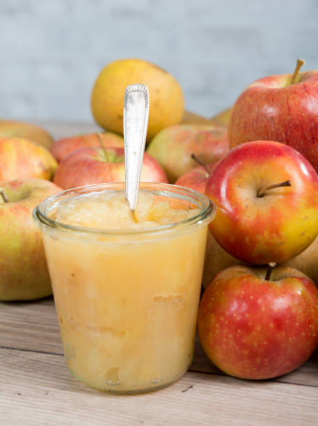 gedünstete äpfel mit äpfeln auf einem holztisch - stewed fruit stock-fotos und bilder